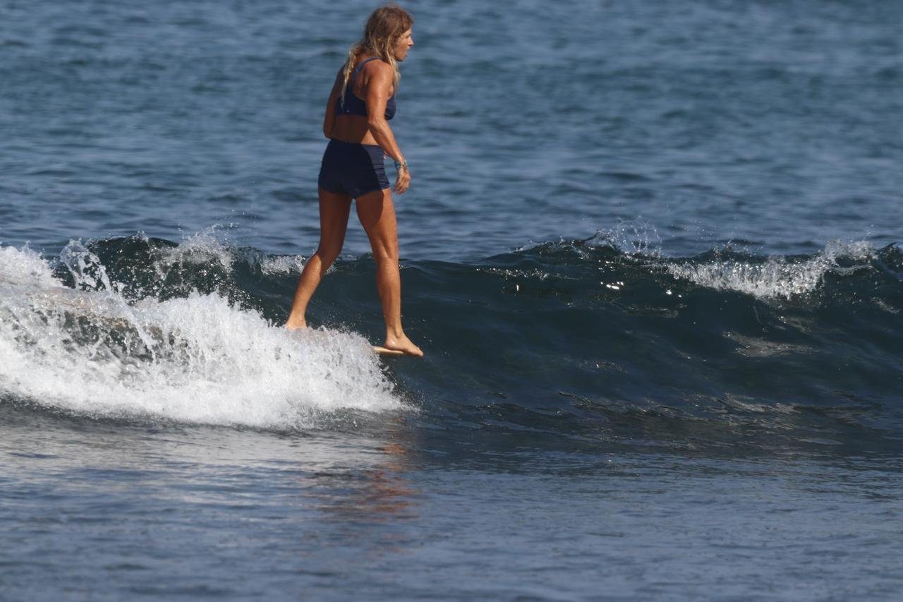 Jordan walking to the nose of a longboard on a small left
