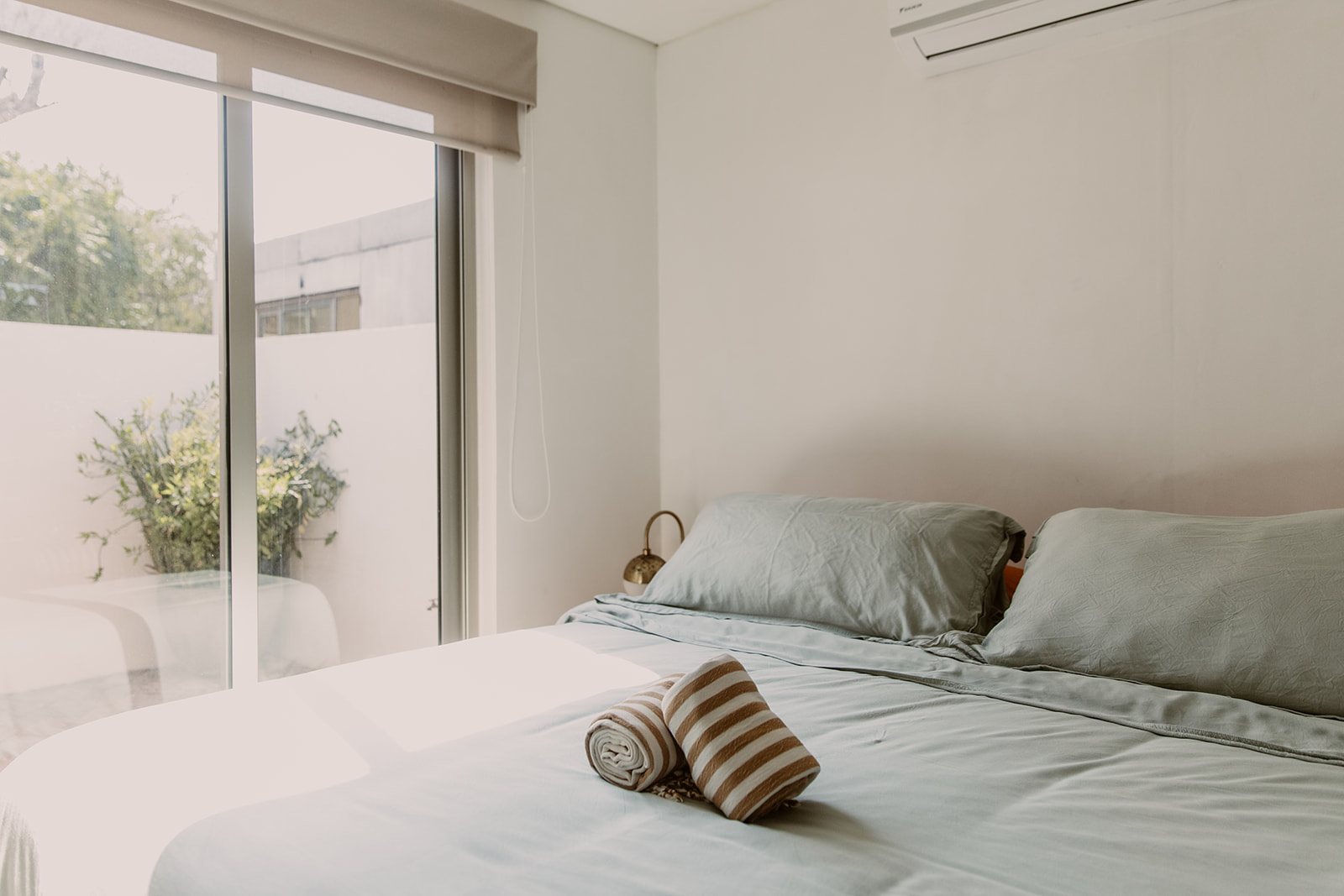 The Poolhouse bedroom with patio view through glass